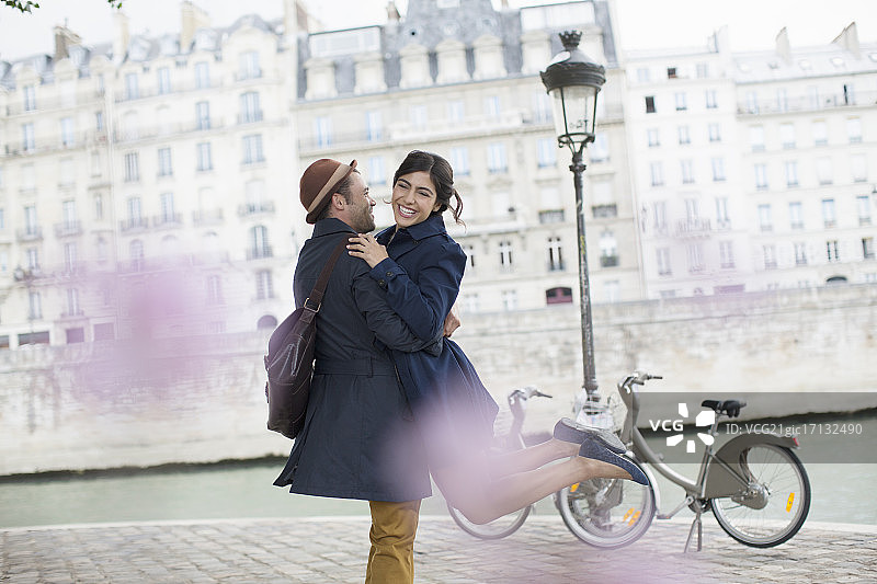一对情侣在法国巴黎塞纳河边拥抱图片素材