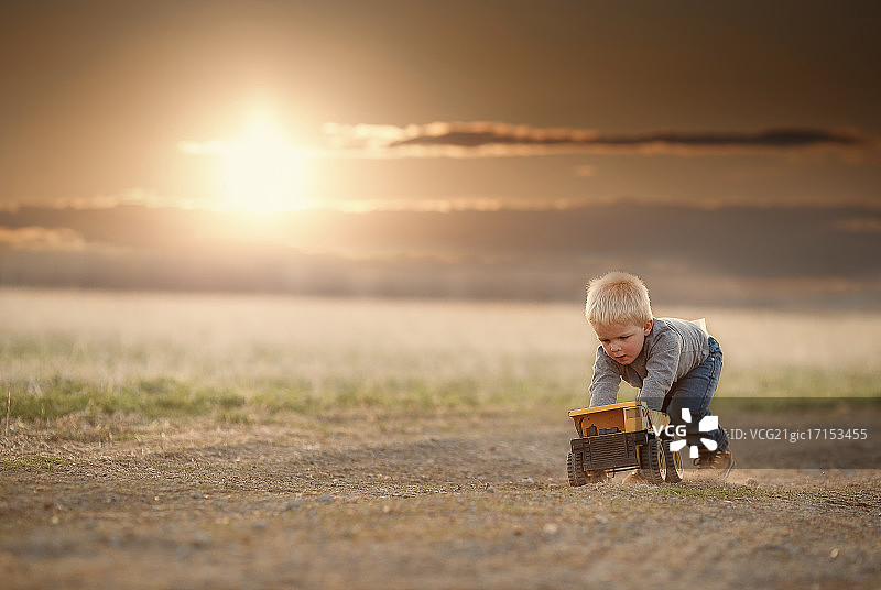 一个男孩在玩玩具卡车。图片素材