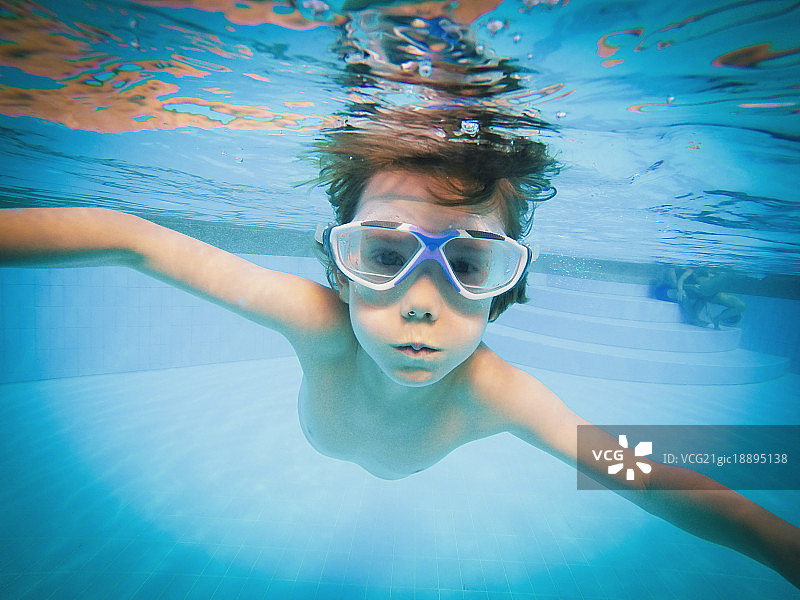 在游泳池里游泳的男孩的肖像图片素材