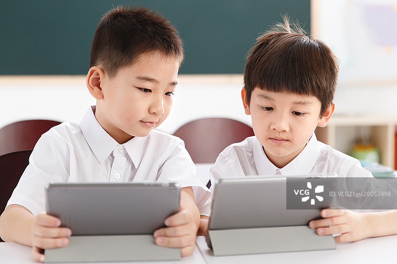 两个小学生在使用平板电脑图片素材