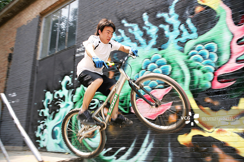 男青年在798艺术区玩自行车图片素材