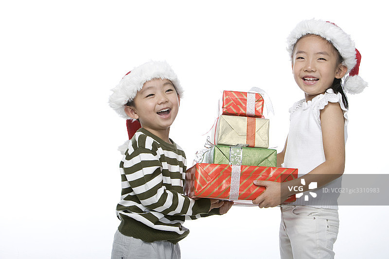 戴着圣诞帽的孩子抱着礼物图片素材