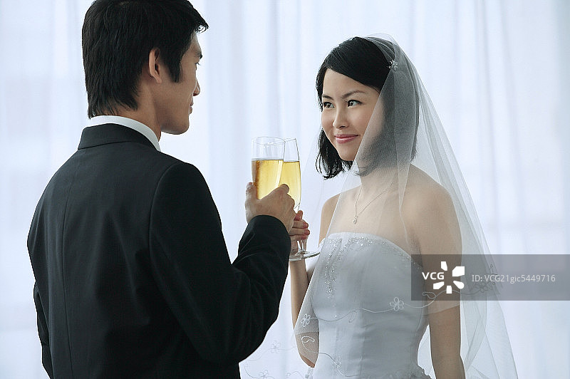 一对新婚夫妇举起他们的香槟酒杯敬酒图片素材