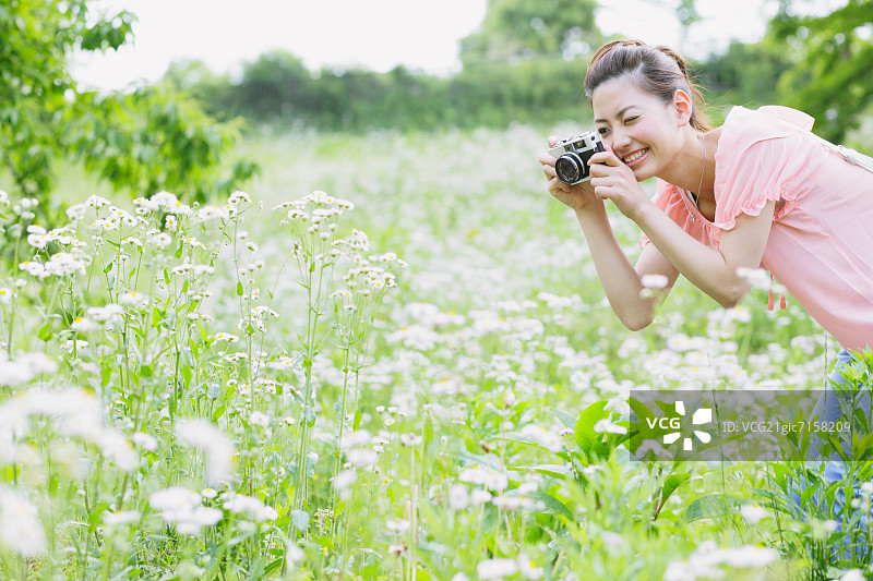 一个在草地上拍照的日本女人图片素材