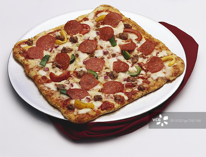 一个有香肠，辣香肠，辣椒和洋葱的方形披萨图片素材