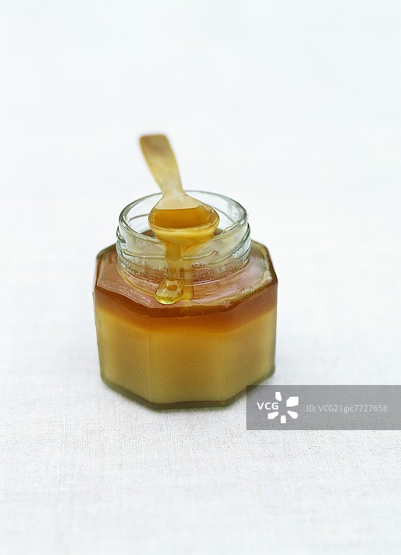 一罐带勺子的蜂蜜图片素材
