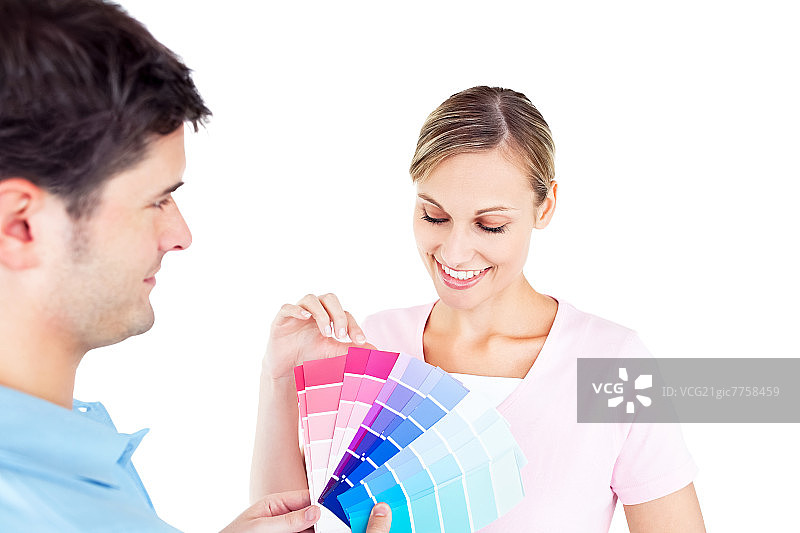 一对喜气洋洋的夫妇正在为他们的新房子挑选房间的颜色图片素材