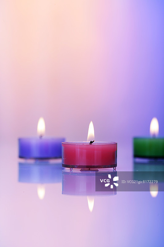 三支蜡烛映衬着多色的背景图片素材