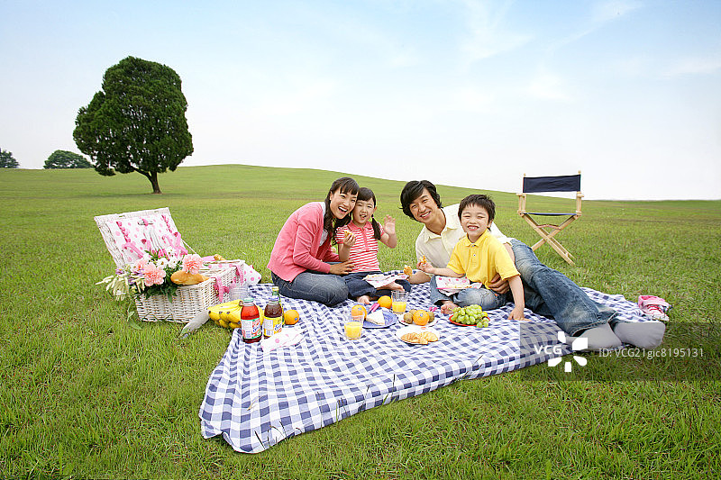 父母和孩子的肖像(6-7)享受野餐，微笑图片素材