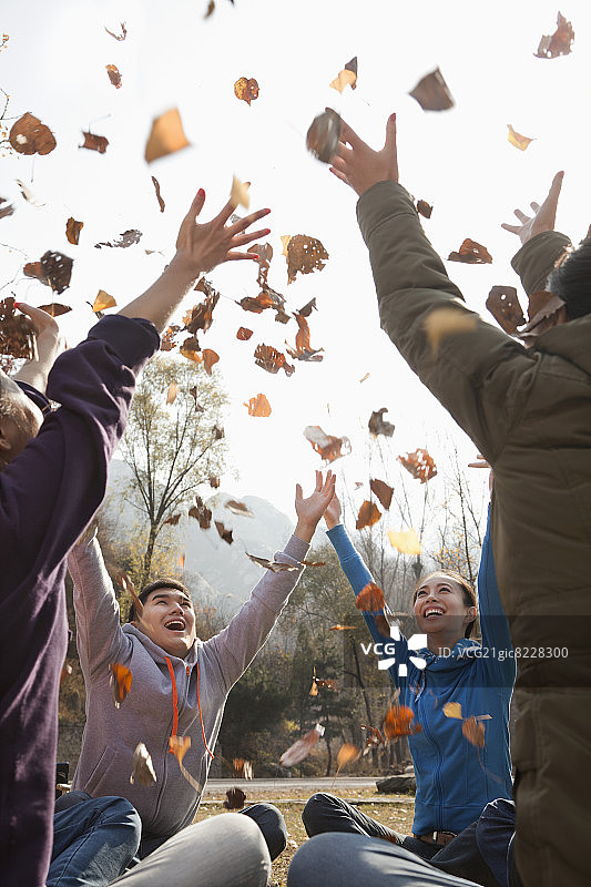 一群年轻人在扔树叶图片素材