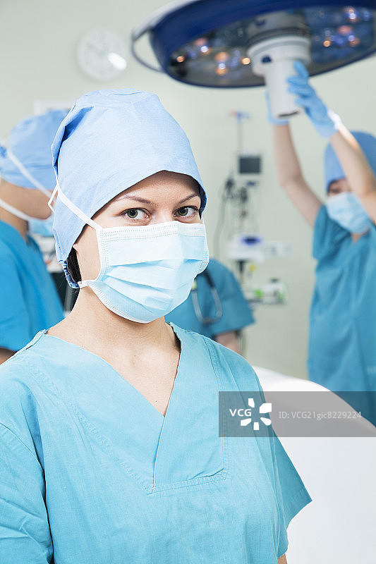 女外科医生戴着外科口罩在手术室的肖像，图片素材
