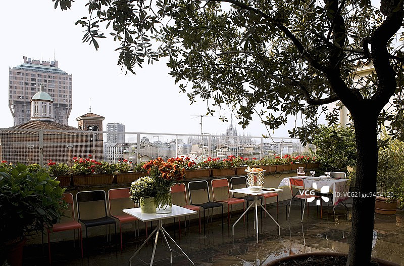 庆祝在屋顶平台上-椅子和桌子在地板湿与雨水图片素材