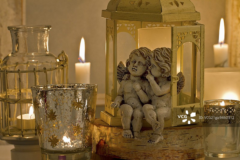 天使雕像坐在灯笼和茶灯座与点燃的蜡烛图片素材