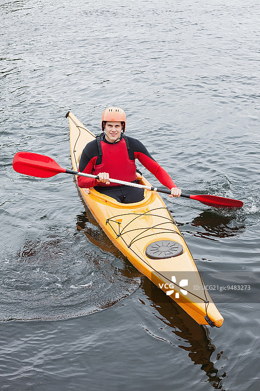 在湖中，皮划艇上的快乐男子对着镜头微笑图片素材