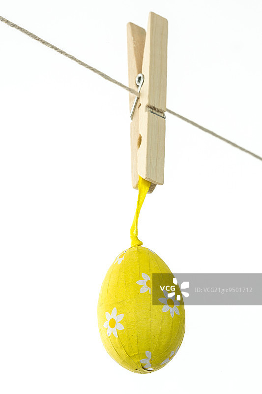 黄色的复活节彩蛋挂在白色的背景上图片素材