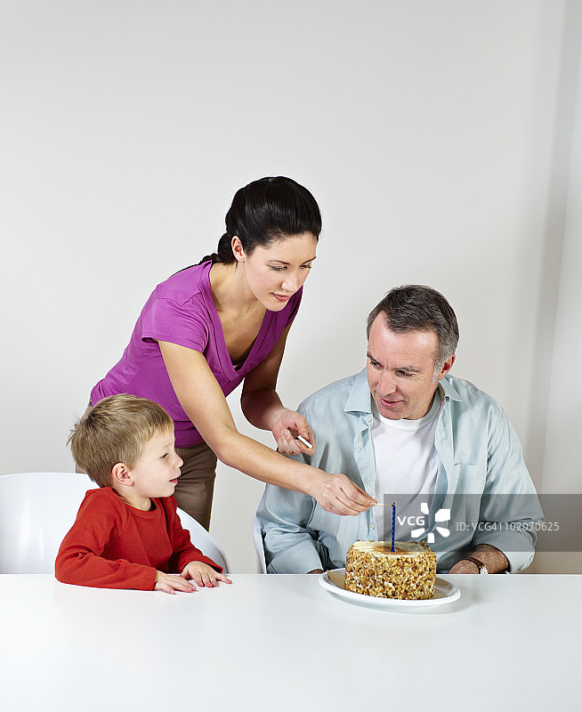 夫妇和小儿子拿着生日蛋糕图片素材