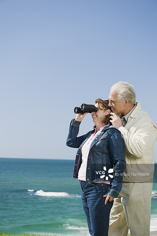 一对夫妇用双筒望远镜看海洋图片素材