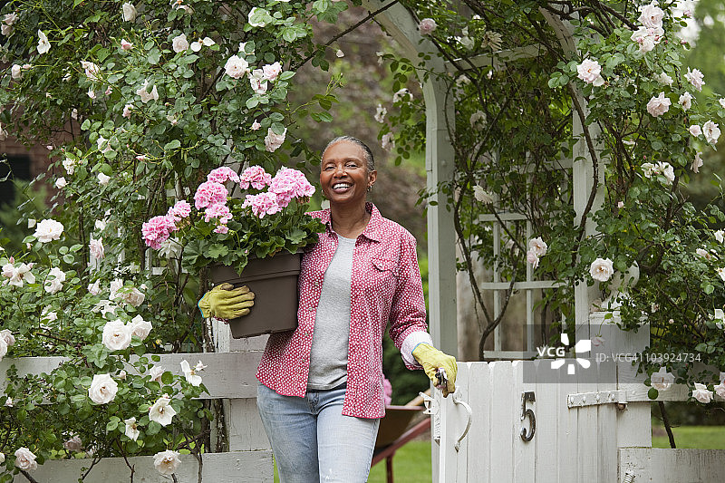 一个黑人妇女在花园里拿着花图片素材