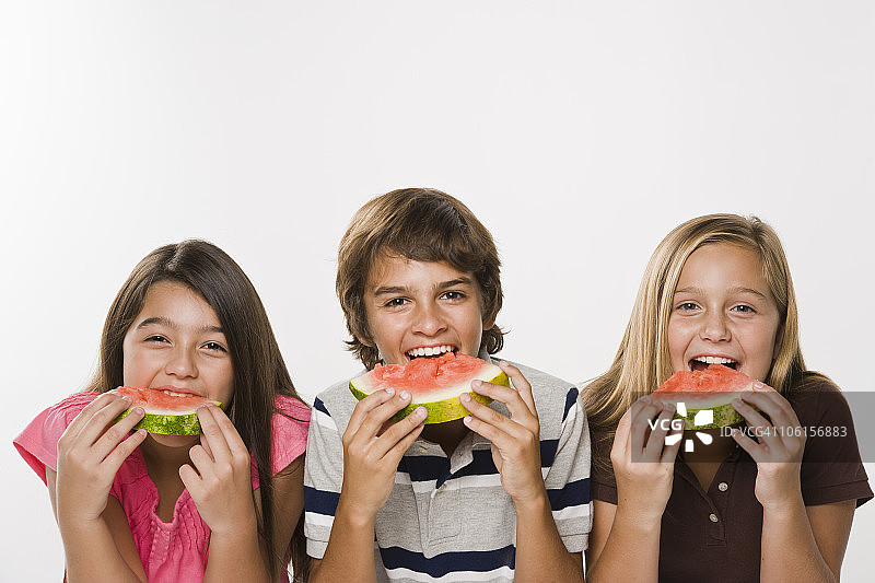 男孩和女孩吃西瓜，微笑，肖像图片素材