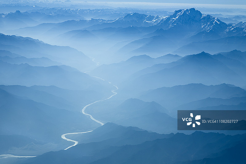 鸟瞰图，河流蜿蜒穿过雾蒙蒙的喜马拉雅山脉图片素材