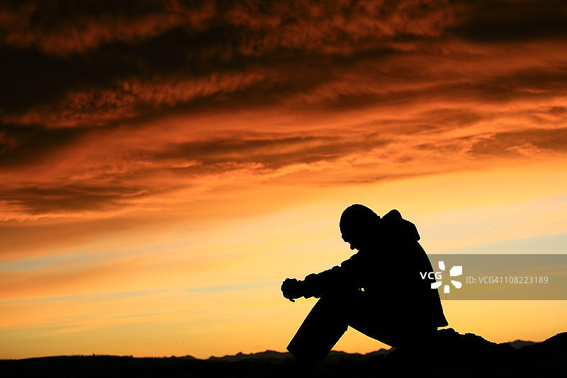 夕阳下坐着的男人的剪影图片素材