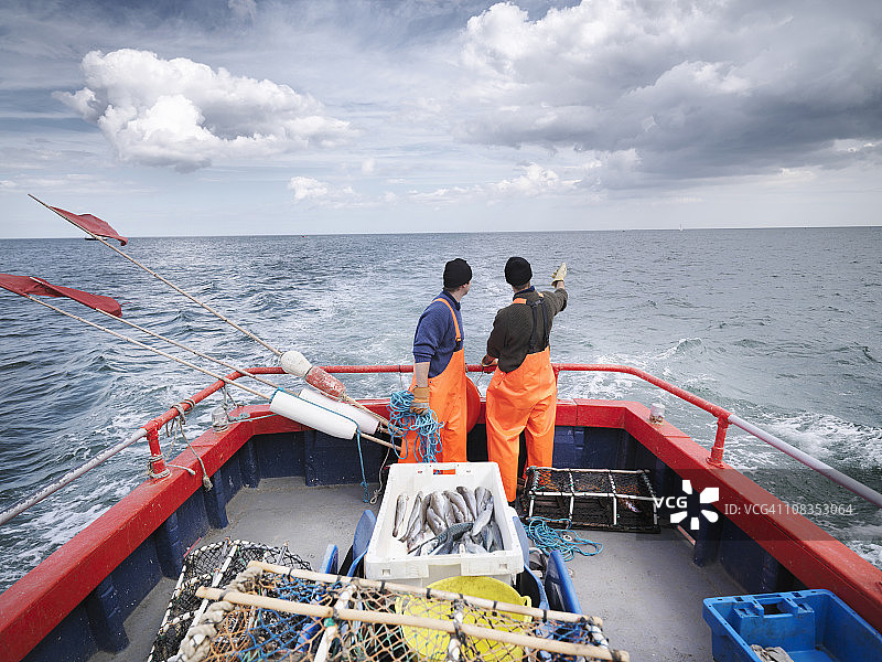渔船上的渔民驶向大海图片素材