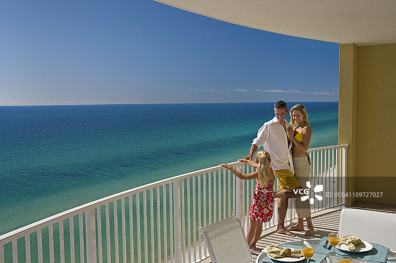 三口之家在酒店阳台俯瞰大海图片素材
