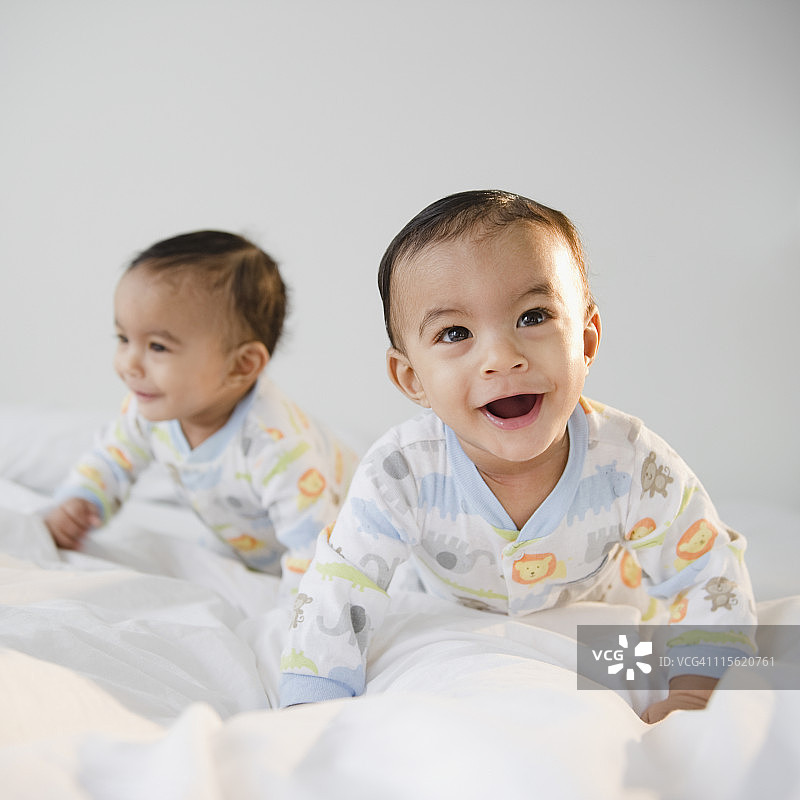 混血双胞胎在床上爬图片素材