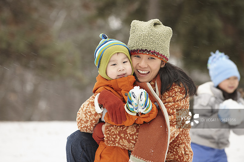一位中国母亲和孩子们在雪中玩耍图片素材