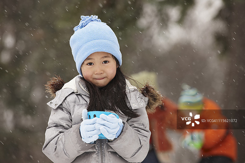 中国女孩在雪中喝热巧克力图片素材
