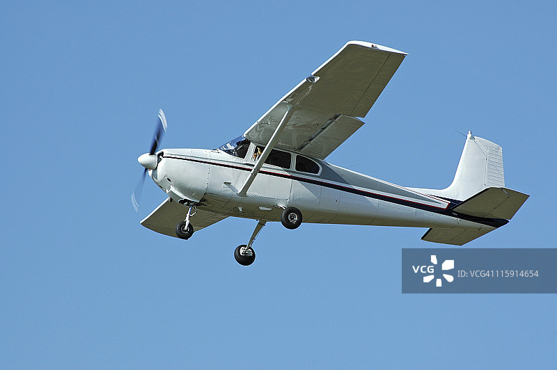 私人飞机塞斯纳182在晴朗的蓝天中飞行图片素材