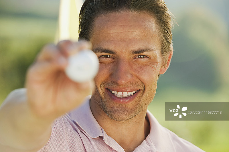 意大利，卡斯泰鲁斯，中年男子拿着高尔夫球，微笑着，肖像图片素材