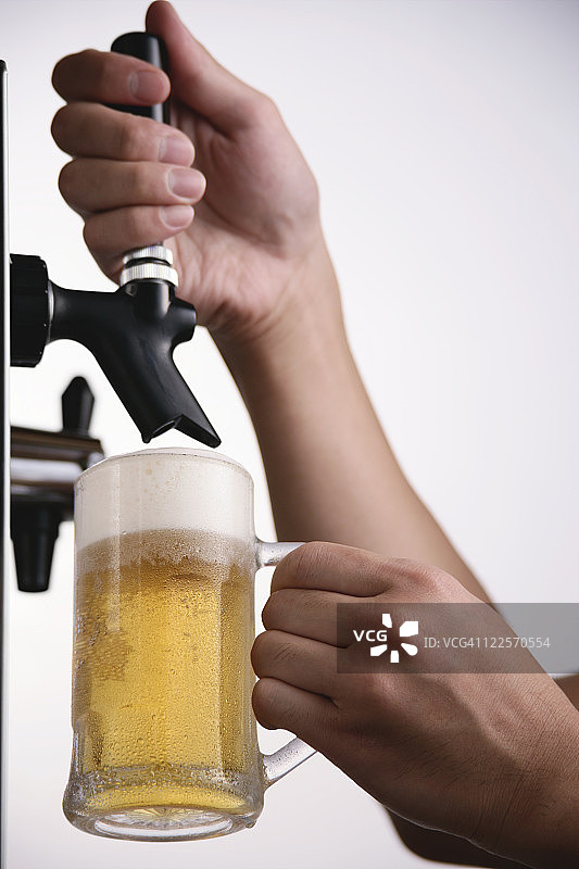 一个往玻璃杯里倒啤酒的人图片素材