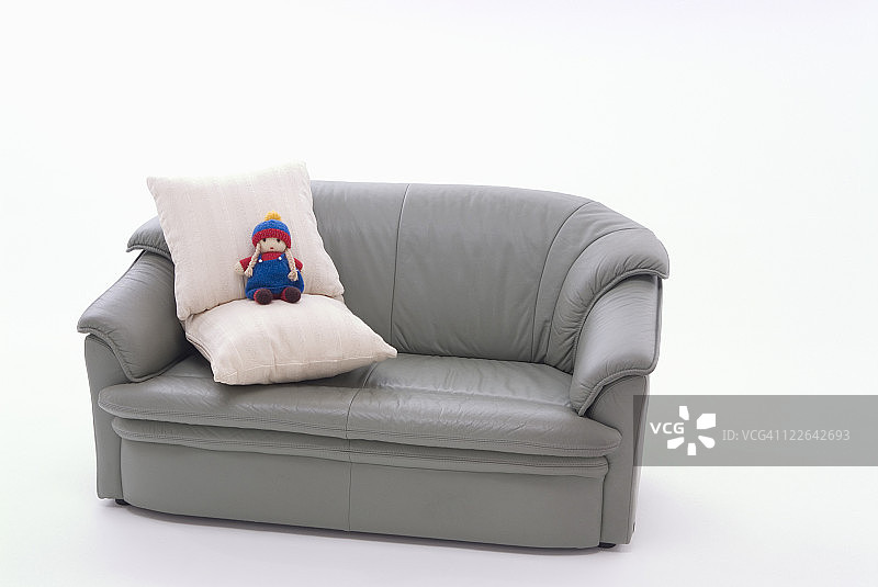 灰色沙发上的垫子和洋娃娃图片素材