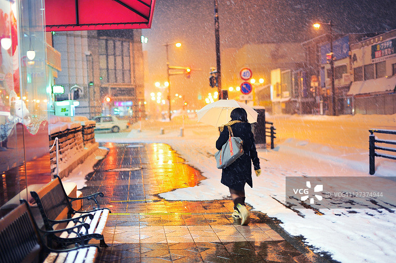 在日本的隆冬，一个女人走在hiroaki市图片素材