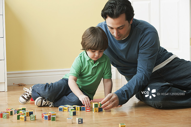白种人父亲和儿子玩字母积木图片素材