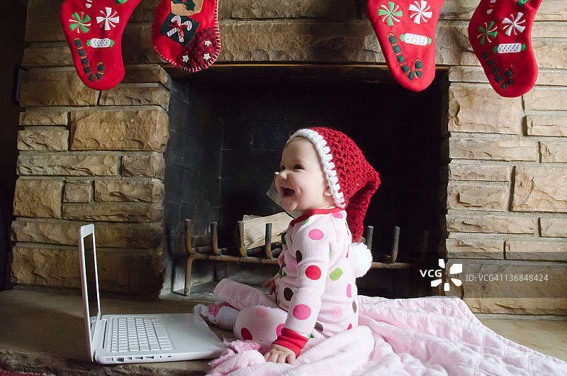 小婴儿的肖像与笔记本电脑圣诞节图片素材