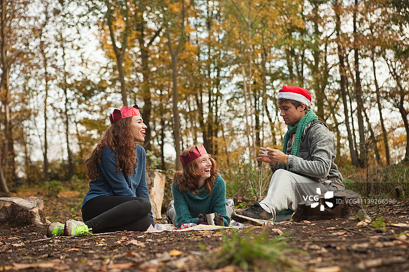 森林里的年轻朋友们戴着圣诞老人的帽子和花冠图片素材