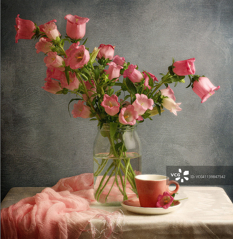 粉红色的铃铛花在罐子和粉红色的杯子图片素材