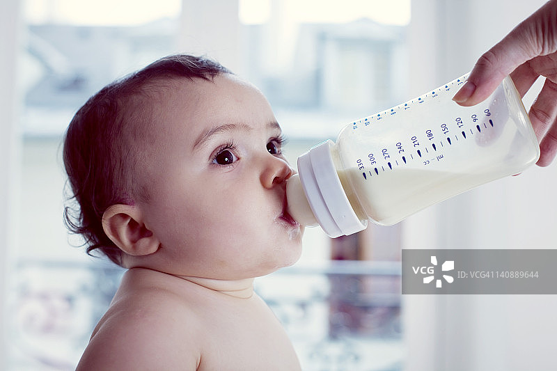 婴儿用奶瓶喝牛奶图片素材