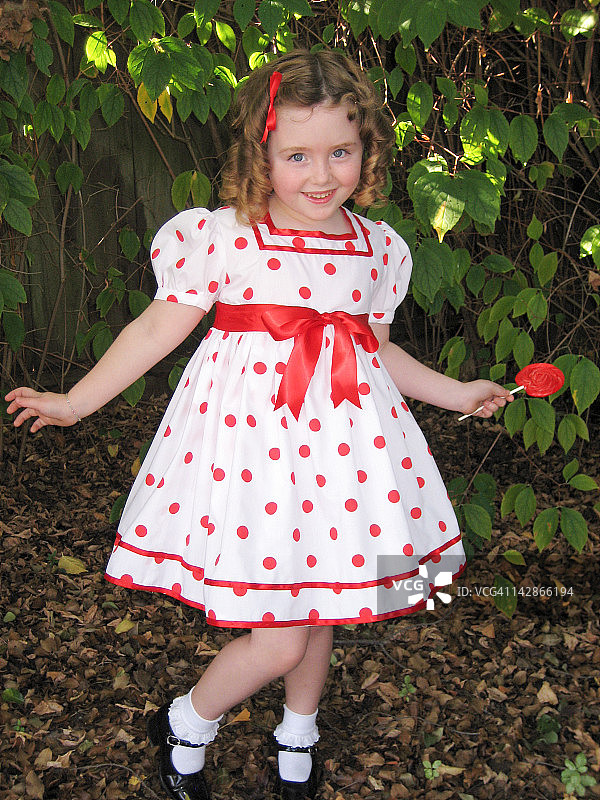 小女孩穿着圆点花纹的裙子图片素材