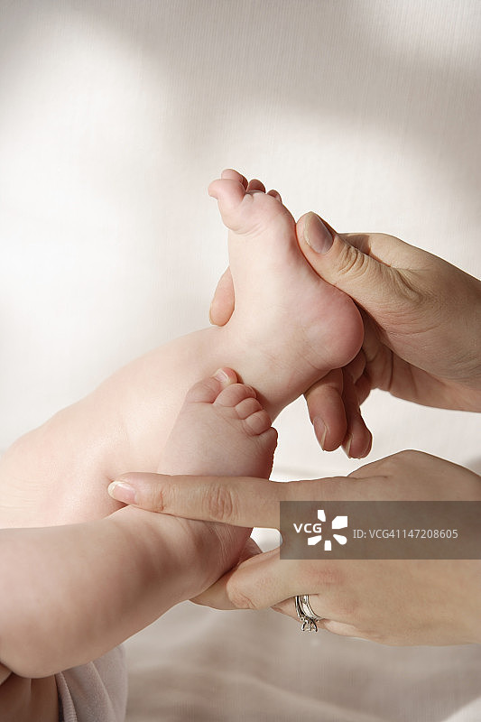 双手抱着宝宝的脚图片素材