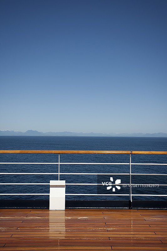 阳光照在一艘客轮的甲板上，背景是加拿大的海岸线图片素材