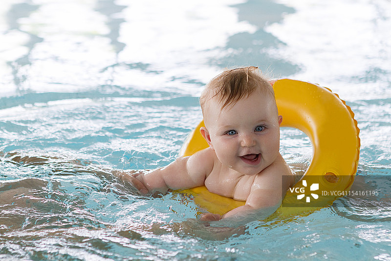 女婴带着救生圈游泳图片素材
