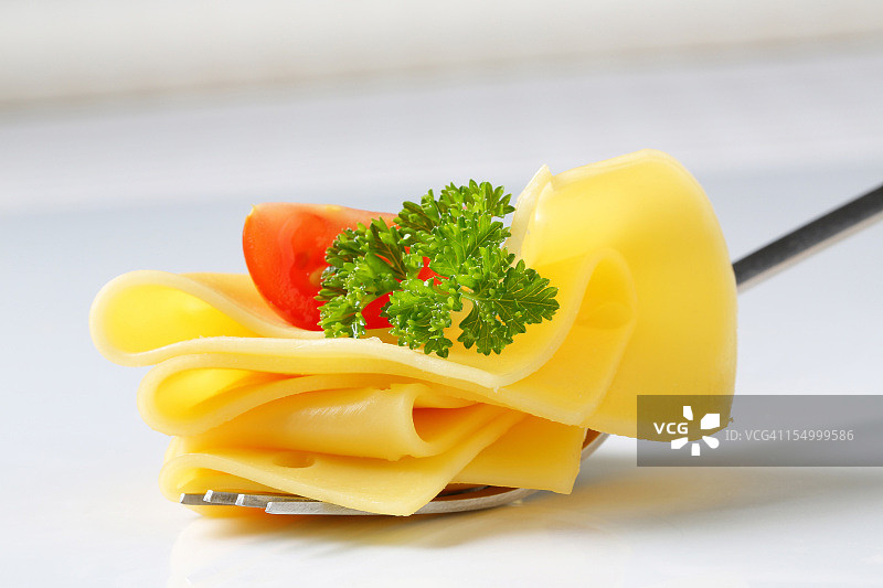 用叉子夹起的奶酪片和蔬菜图片素材