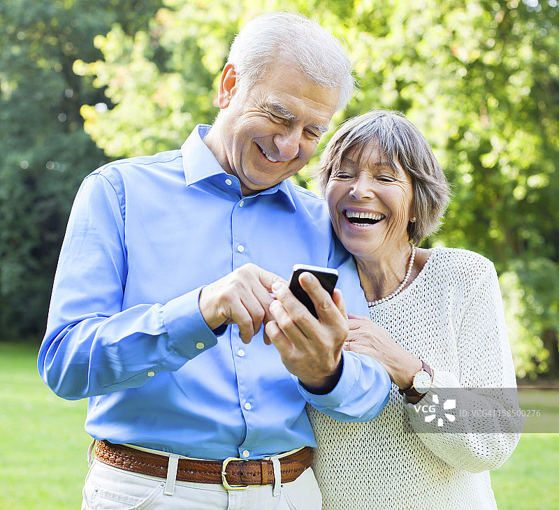 一对老年夫妇在智能手机上打字图片素材