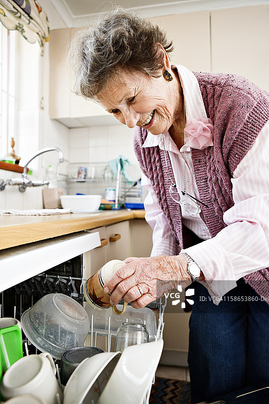 微笑的老妇人在洗碗图片素材