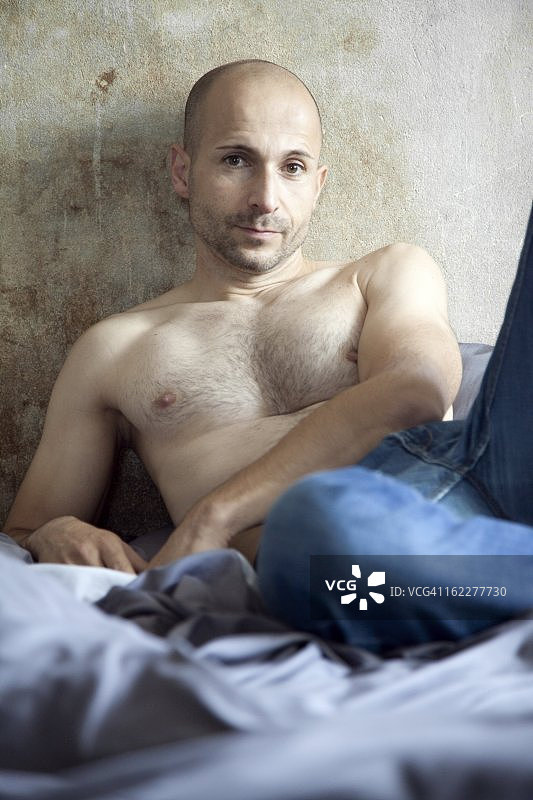 裸胸男，留着设计好的胡茬躺在床上图片素材