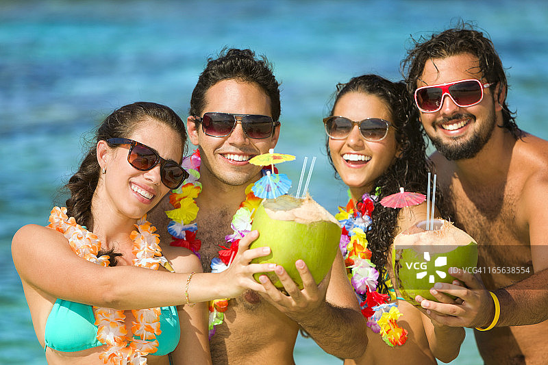 一群年轻人在热带绿松石海滩上干杯图片素材