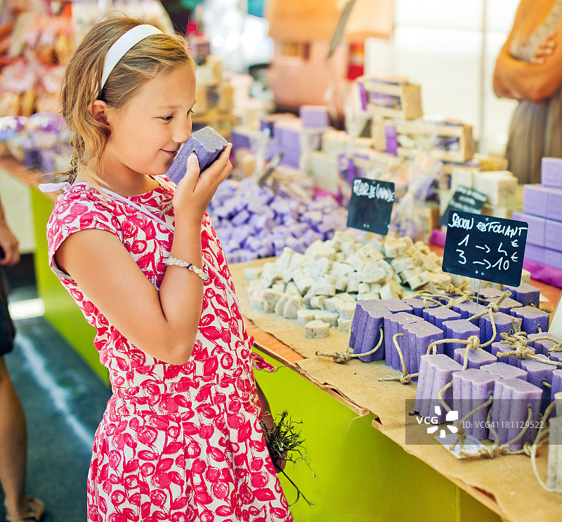 一个孩子在普罗旺斯的农贸市场上嗅肥皂图片素材